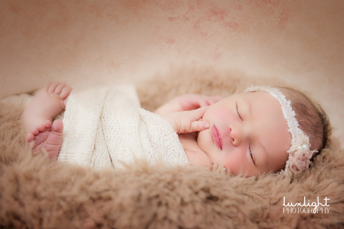newborn baby in soft fur for photography session