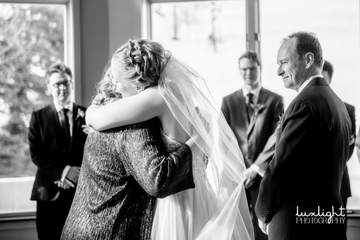 bride hugging parents during wedding