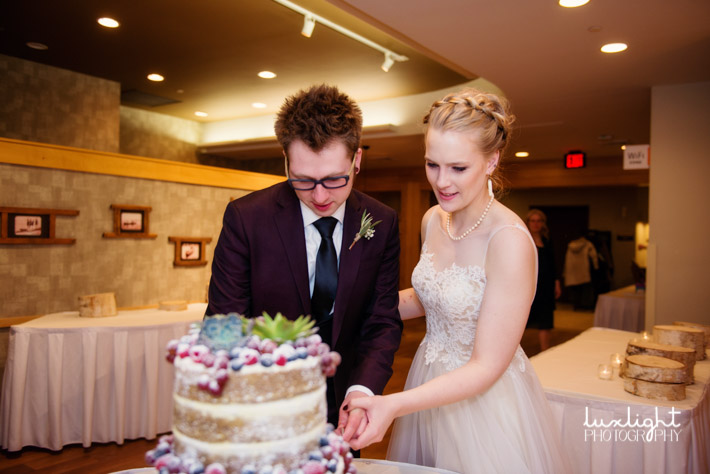 bride and groom cutting their cake for winter wedding