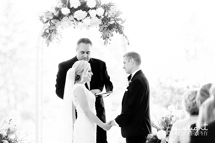 wedding ceremony with white floral arch