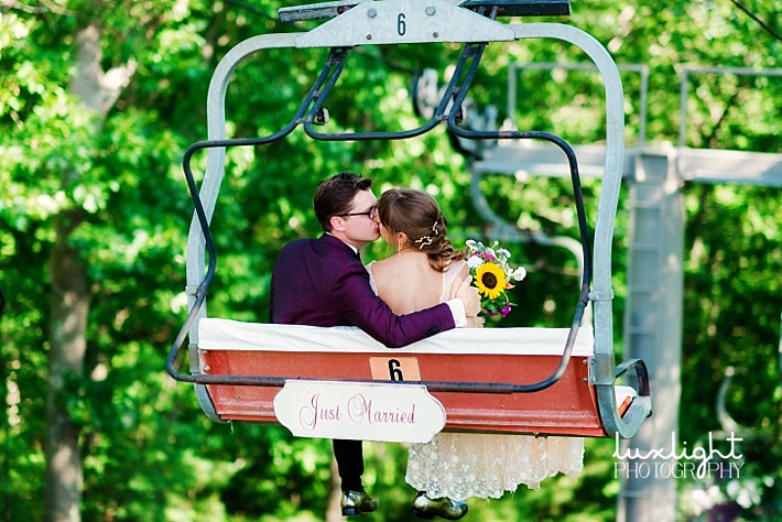 bride and groom riding down chair lift 