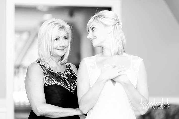 mother and bride putting on dress