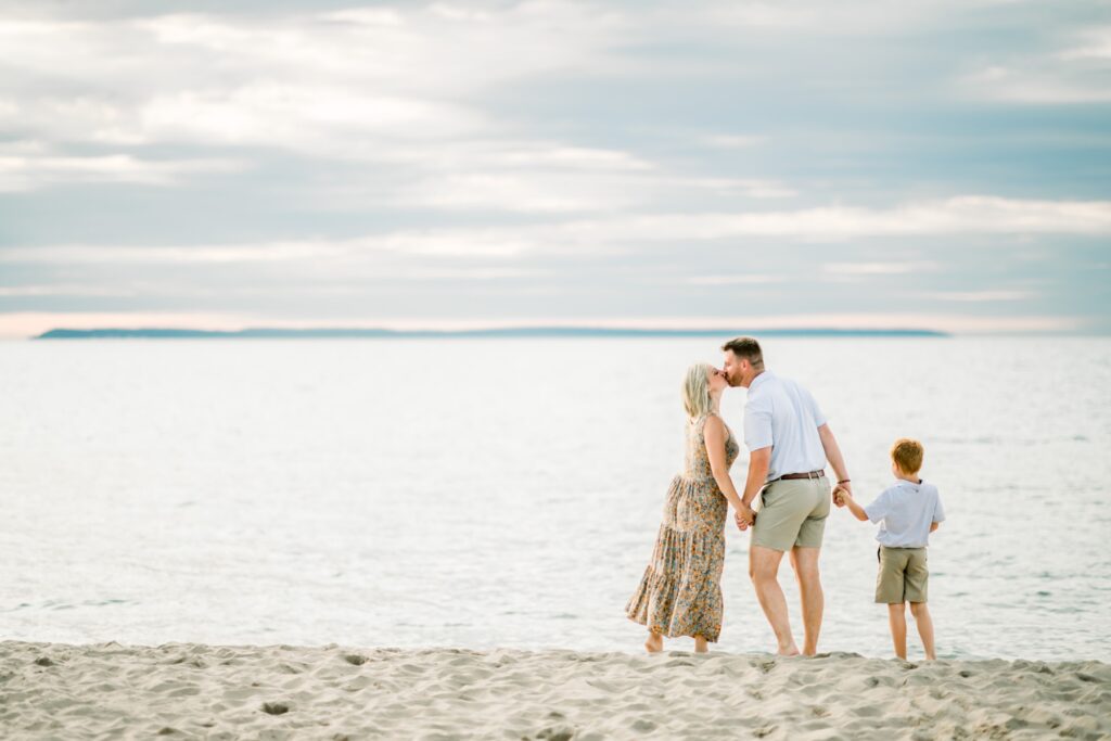 Sunset family photos on the beach with Lake Michigan waves in the background near Traverse City