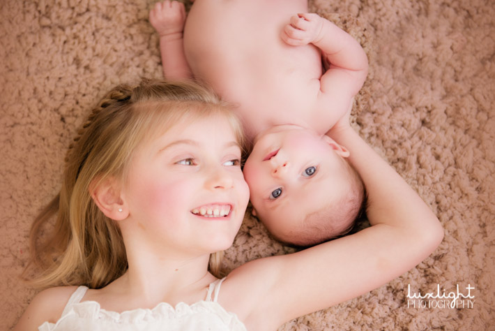 sibling pose with newborn baby photography