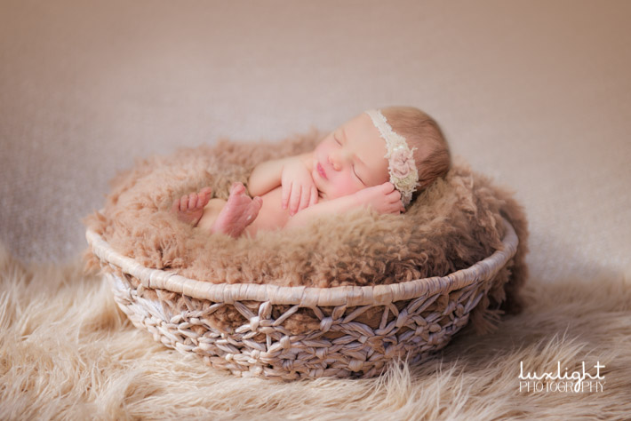 newborn in basket for photography session