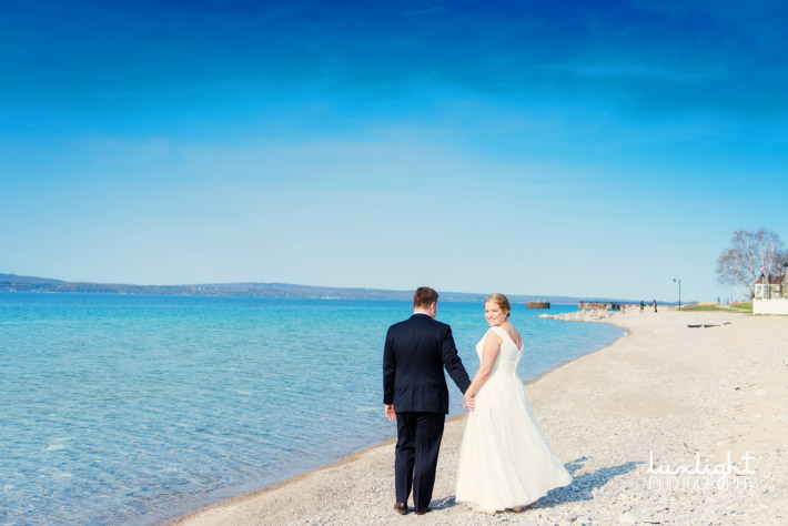Bride and groom share walk down the beach